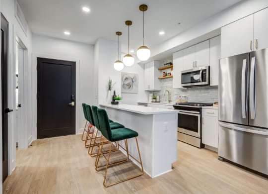 a kitchen with stainless steel appliances and an island with green chairs at Rialto, Washington, 20002