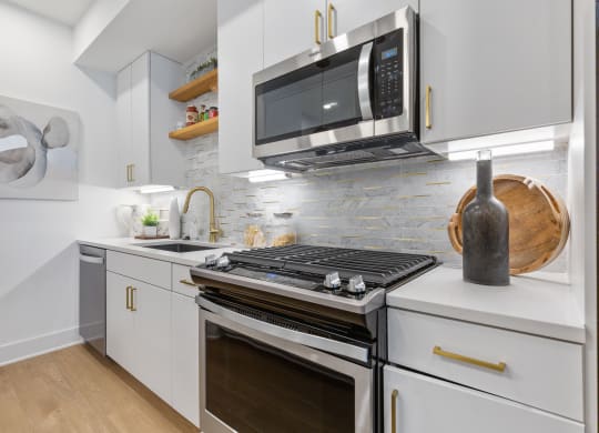 a kitchen with white cabinets and a stove and a microwave at Rialto, Washington, DC 20002