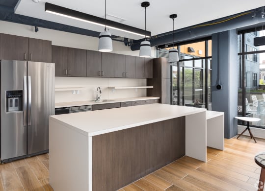 a kitchen with a large island and a stainless steel refrigerator