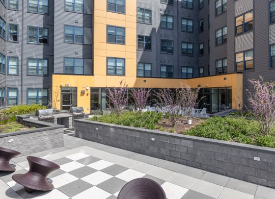 a view of the courtyard of an apartment building with a checkered sidewalk