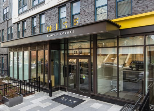the entrance of a building with a large glass door and a sign that reads rise