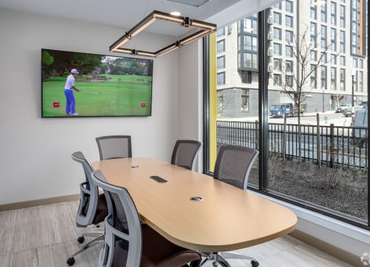 a conference room with a tv and a table with chairs