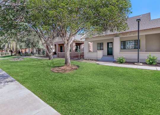 A tree in front of a building with the number 101 on it at Roosevelt Commons Apartments, Phoenix, AZ, 85003
