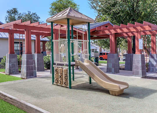 A playground with a slide and a red structure at Roosevelt Commons Apartments, Phoenix, AZ