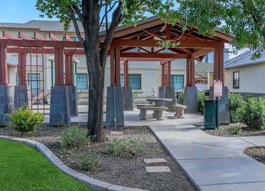 A covered outdoor seating area with a table and chairs at Roosevelt Commons Apartments, Phoenix, 85003
