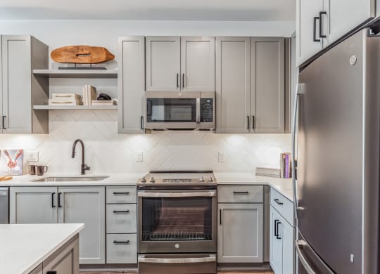 a kitchen with stainless steel appliances and white cabinets at South and Hollis, Charlotte, 28209