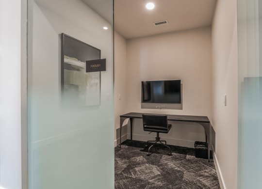 an office with a desk and a tv in a room with a glass door at South and Hollis, North Carolina