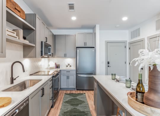 a renovated kitchen with stainless steel appliances and white countertops at South and Hollis, Charlotte, NC