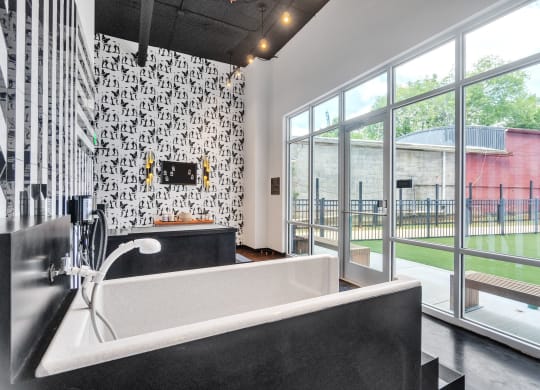a bathroom with a tub and a large window at South and Hollis, Charlotte, 28209