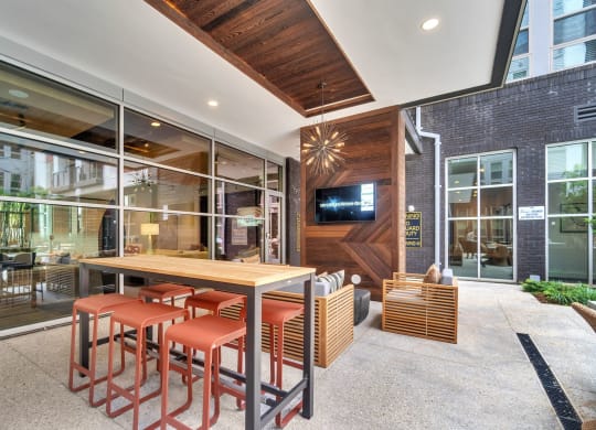 a dining area with a wooden table and chairs and a tv on the wall at South and Hollis, North Carolina
