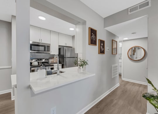 a kitchen with white cabinetry and a white counter top with a vase of flowers on  at Brampton Moors, North Carolina, 27513