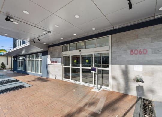 the lobby of a building with glass doors and a wood floor at The Gramax, Silver Spring