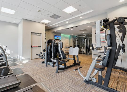 a gym with weights and cardio equipment in a building at The Gramax, Silver Spring, 20910