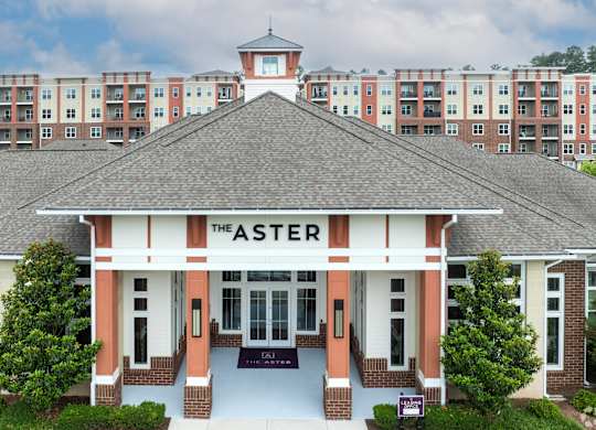 The Aster building is in front of apartment buildings.