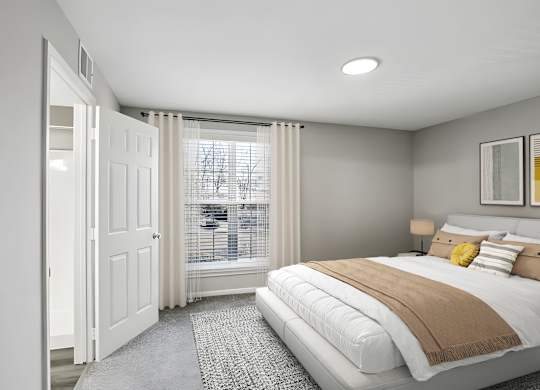 A bedroom with a large bed and a window with blinds.