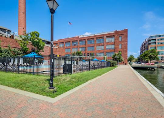 A brick walkway leads to a building with a flag on top.