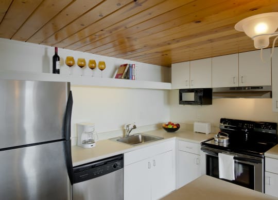 a kitchen with white cabinets and a stainless steel refrigerator at Tindeco Wharf, Baltimore