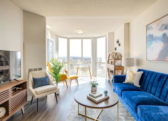 a living room with a blue couch and a table at Lincoln Old Town, Alexandria, VA 22314