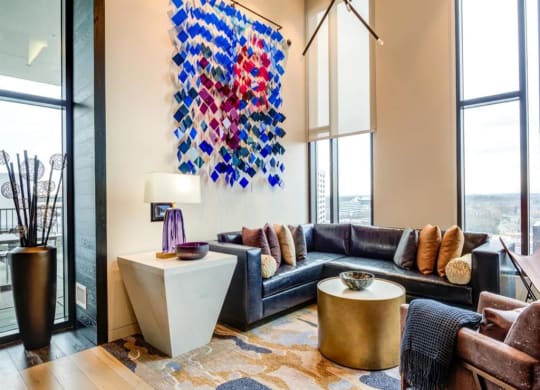 a living room with a black couch and a large colorful painting on the wall at The Boro, Tysons, VA