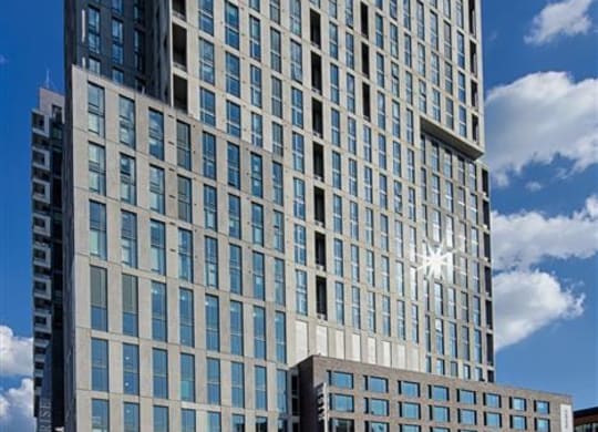a tall building with a blue sky in the background at The Boro, Tysons, 22102