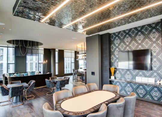 a room with a large table and chairs and a large tv on the wall at The Boro, Tysons