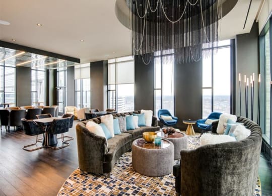 a lounge area with couches and chairs and a large chandelier at The Boro, Tysons, VA 22102