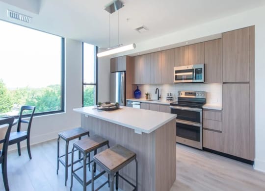 a kitchen with a large center island next to a stove top oven at The Boro, Virginia, 22102
