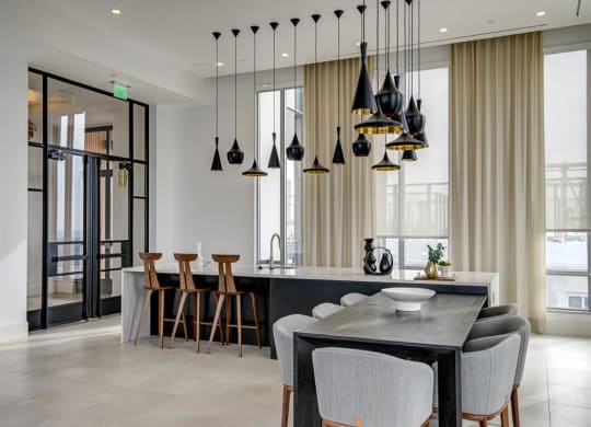 a kitchen with a long counter and a table at The Boro, Tysons