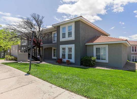 A grey house with a red roof and white windows at West Park Apartments, Albuquerque