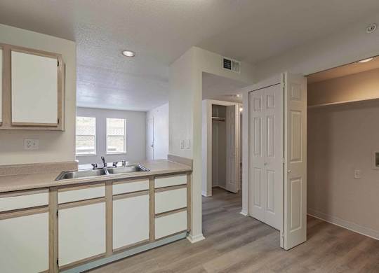 A kitchen with a sink and a white door at West Park Apartments, Albuquerque