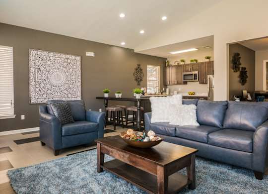 A living room with a blue couch and a coffee table at West Park Apartments, New Mexico