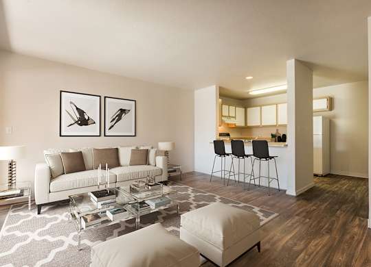 A modern living room with a white couch, a glass coffee table, and a rug with a geometric pattern at West Park Apartments, Albuquerque, NM