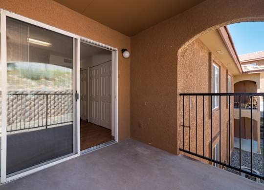 A balcony with a view of a fence and a building at West Park Apartments, Albuquerque, 87114