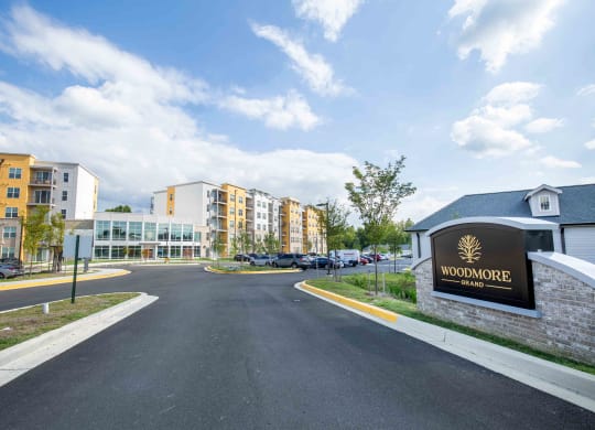 a road leading to a building with a sign at Woodmore Grand, Bowie, 20721