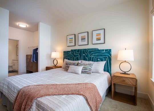 a bedroom with a bed and pictures on the wall at Woodmore Grand, Bowie