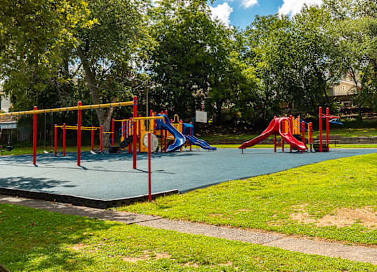 A playground with a blue slide and red and yellow play structures at Vermella Lyndhurst apartments, Lyndhurst, New Jersey