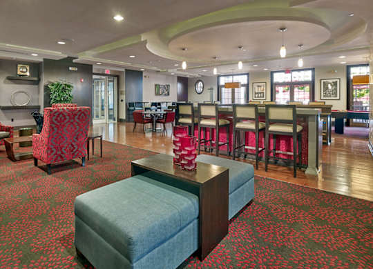 A large room with a green ottoman in the middle of it at Vermella Lyndhurst apartments, Lyndhurst, New Jersey