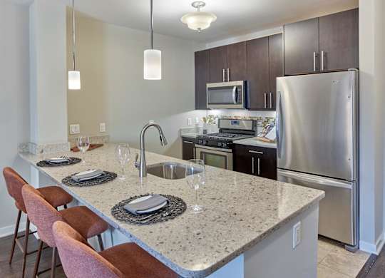 Functional kitchen island and stainless steel appliances at Vermella Lyndhurst apartments, New Jersey, 07071