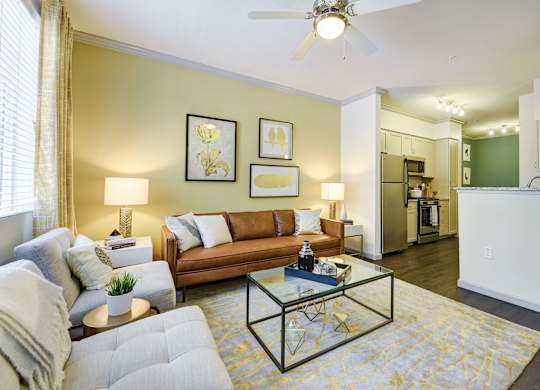 A living room with a grey couch, a coffee table, and a ceiling fan.