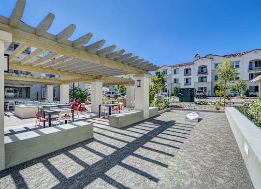 A sunny day at a modern outdoor seating area with a wooden pergola.