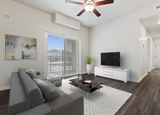 a living room with a ceiling fan and a large window