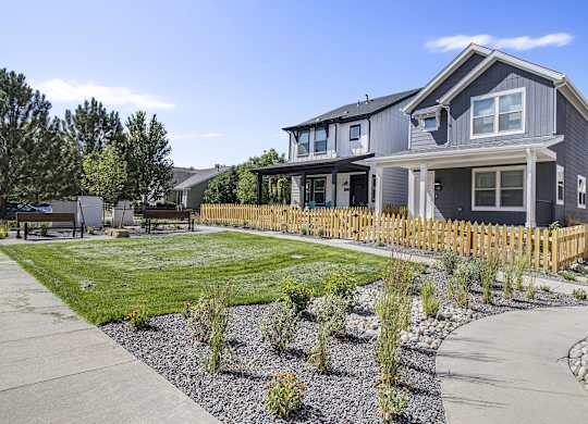 a blue house with a yard and a sidewalk