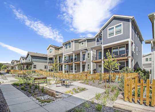 an outdoor area with a picnic table in front of an apartment building