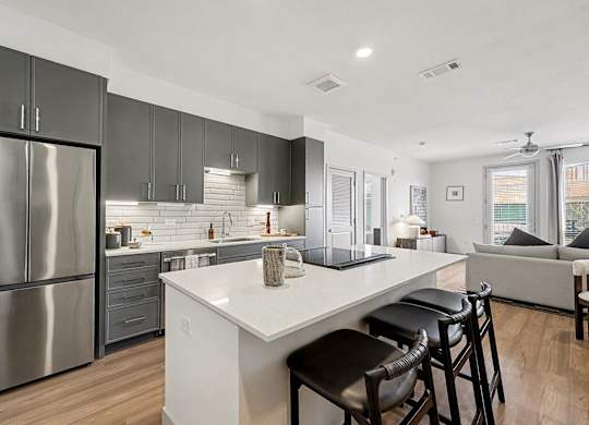 A modern kitchen with a large island and stainless steel appliances.