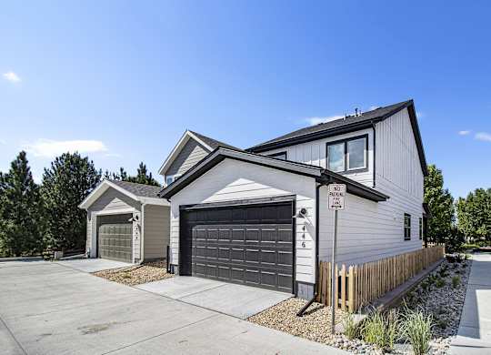 a white house with a garage door and a sidewalk