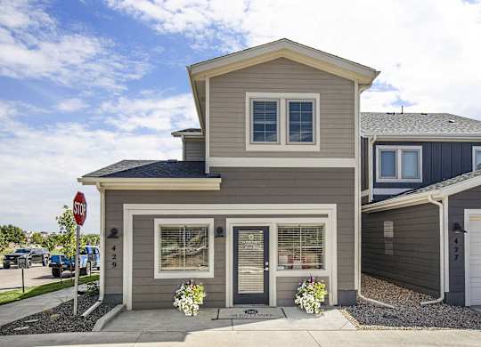 a tan house with a stop sign in front of it