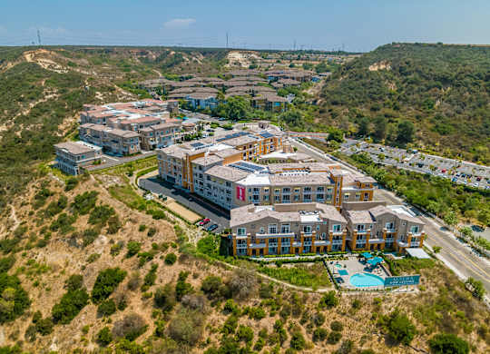 A large building complex with a swimming pool in the foreground.