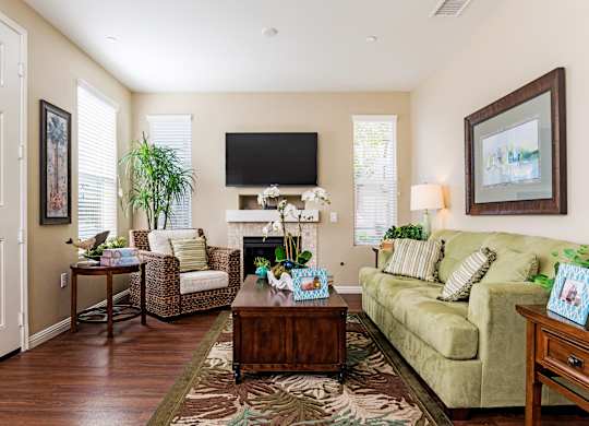 A living room with a couch, chair, and a television.