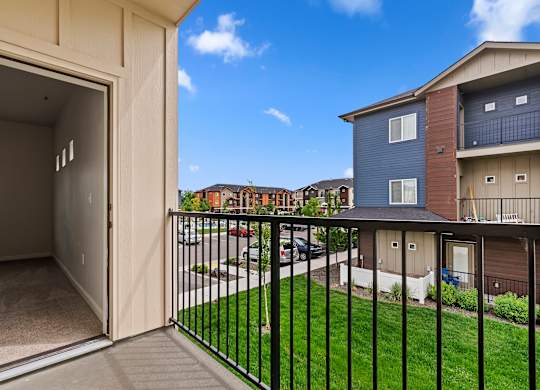 the view from the balcony of an apartment building with a yard and balcony railings