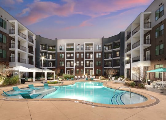 a swimming pool at an apartment complex with an infinity pool